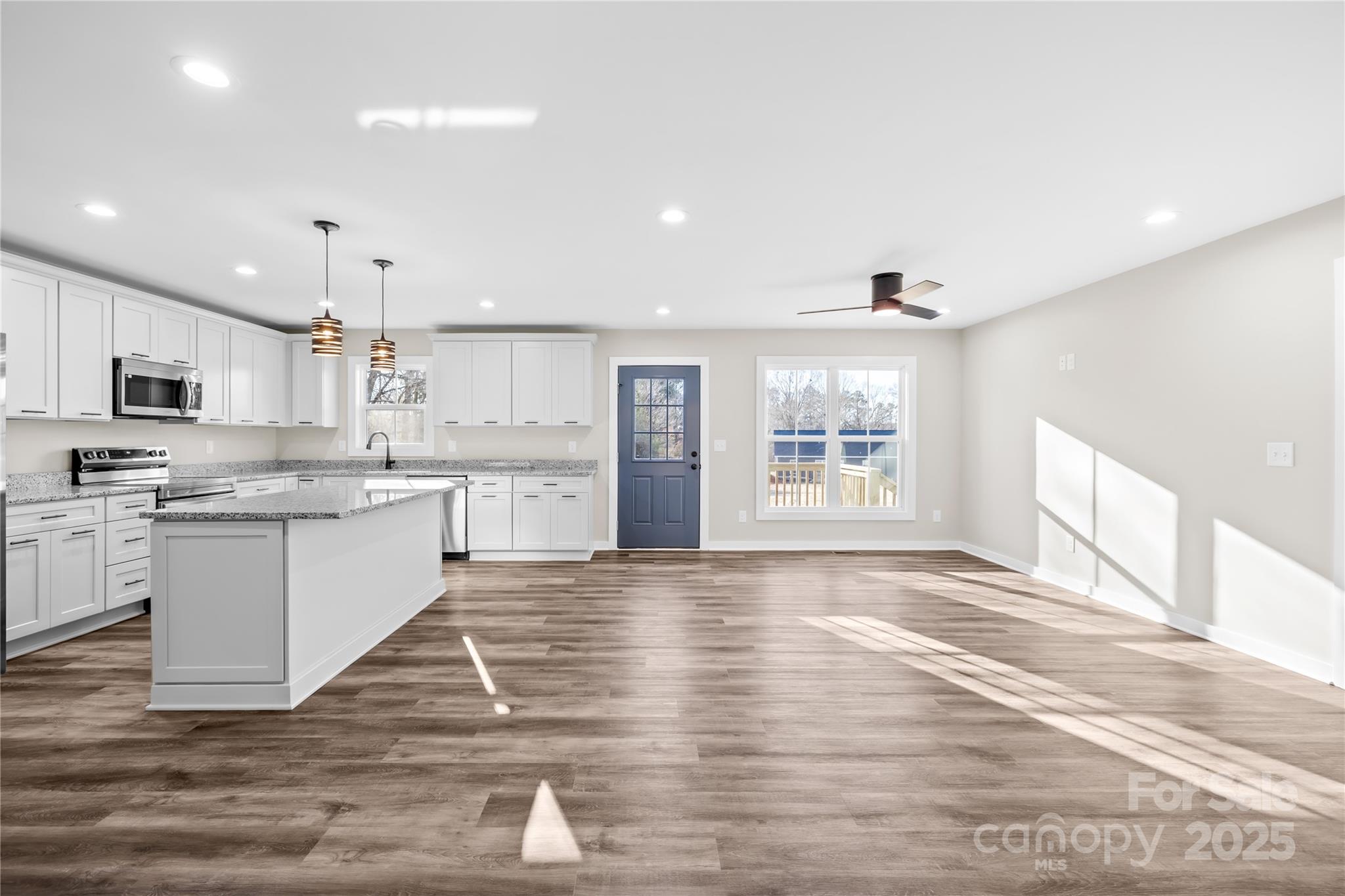 177 Monticello Road Statesville, NC 28625 - Photo 8 of 39 a large white kitchen with kitchen island a sink dishwasher a stove and a refrigerator with wooden floor