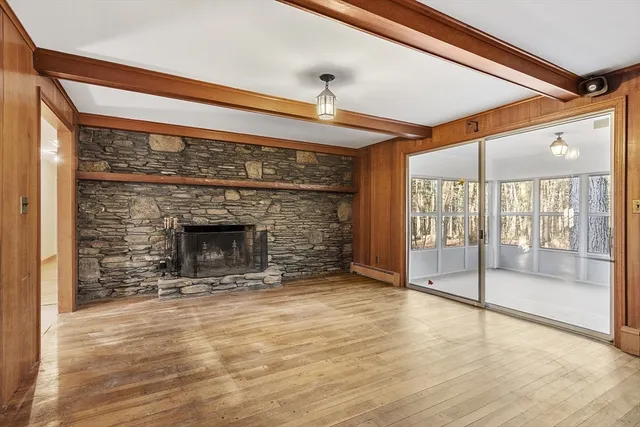 a view of empty room with wooden floor and fireplace