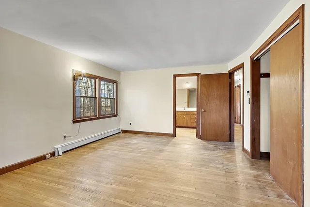 a view of an empty room with window and closet area
