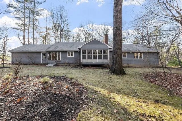 a view of a house with a yard covered in the forest