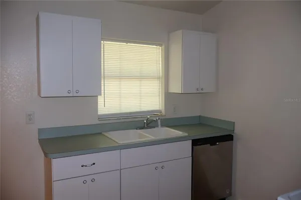 a kitchen with a sink cabinets and a window