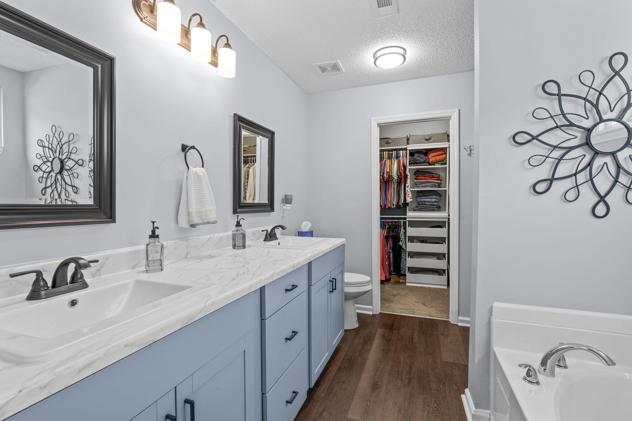 6809 Fereday Court Raleigh, NC 27616 - Photo 13 of 21 a spacious bathroom with a double vanity sink a mirror and a bathtub