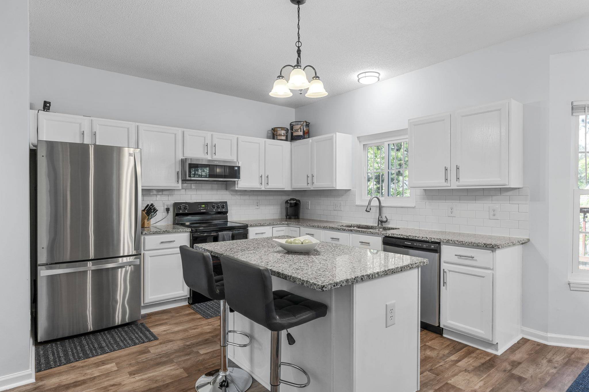 6809 Fereday Court Raleigh, NC 27616 - Photo 5 of 21 a kitchen with stainless steel appliances granite countertop a sink stove a refrigerator and white cabinets with wooden floor