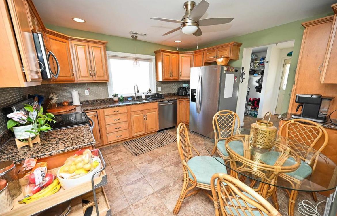 214 Sunray Road Del Haven, NJ 08251 - Photo 8 of 23 a large kitchen with stainless steel appliances granite countertop a stove a sink a dining table and chairs with wooden floor
