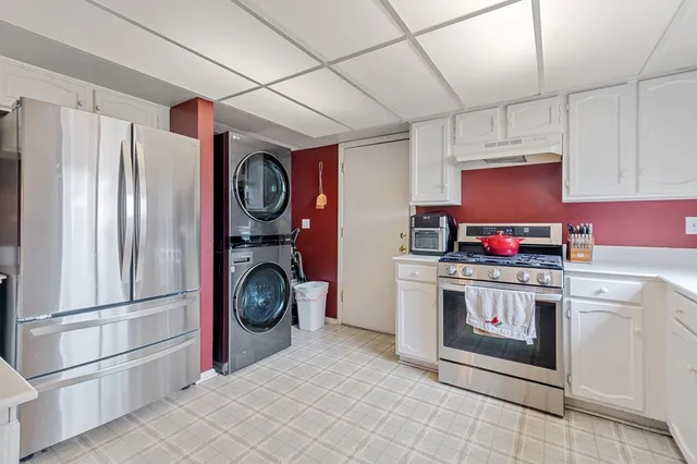 a kitchen with stainless steel appliances granite countertop a refrigerator and a stove top oven
