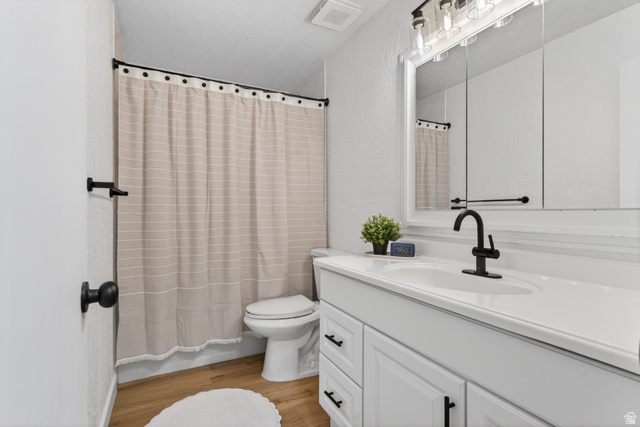 489 Owens Street Layton, UT 84041 - Photo 9 of 25 Bathroom featuring vanity, light wood finished floors, a shower with shower curtain, a textured wall, and a textured ceiling