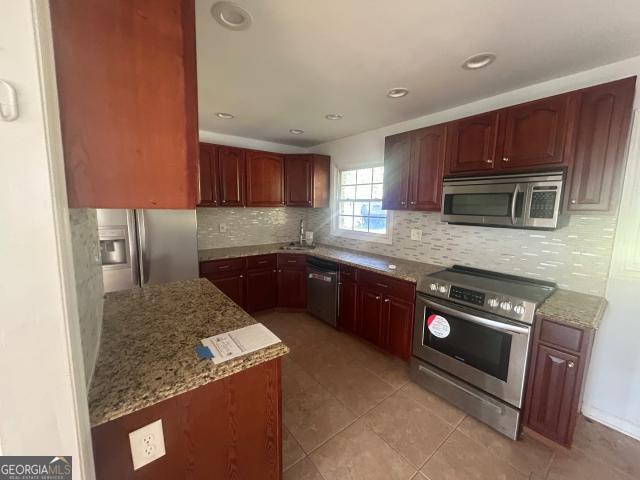4125 O'Hara Road Forest Park, GA 30297 - Photo 8 of 20 a kitchen with stainless steel appliances granite countertop a stove a sink and a microwave