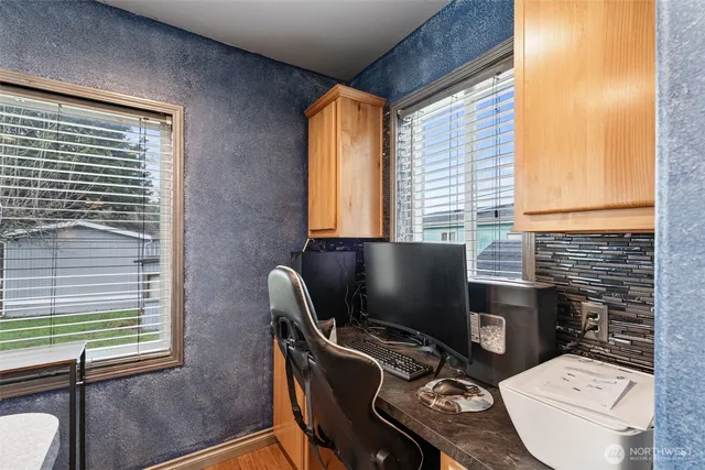 a view of a workspace with furniture and a window