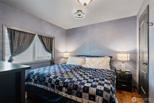 a bedroom with a bed and wooden floor