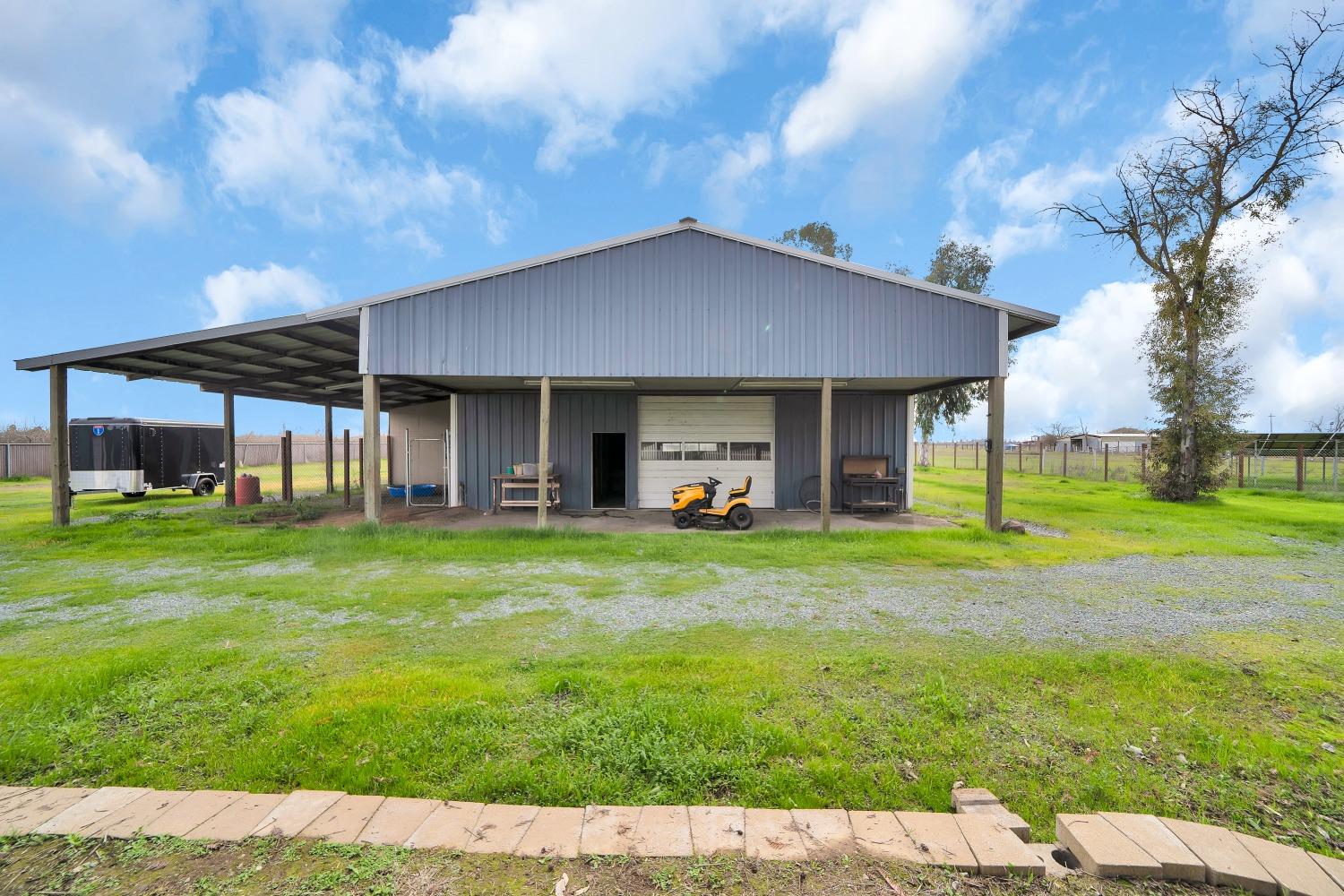 5420 East Jahant Road Galt, CA 95632 - Photo 19 of 73 a front view of a house with a big yard and a garden