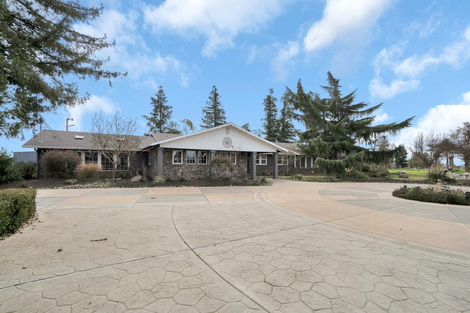 5420 East Jahant Road Galt, CA 95632 - Photo 4 of 73 a front view of a house with yard and tress in front of it