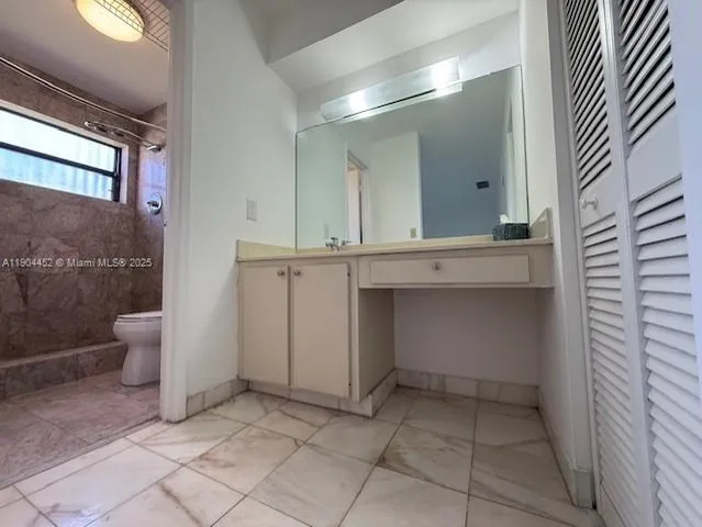 a bathroom with a sink a toilet and a mirror