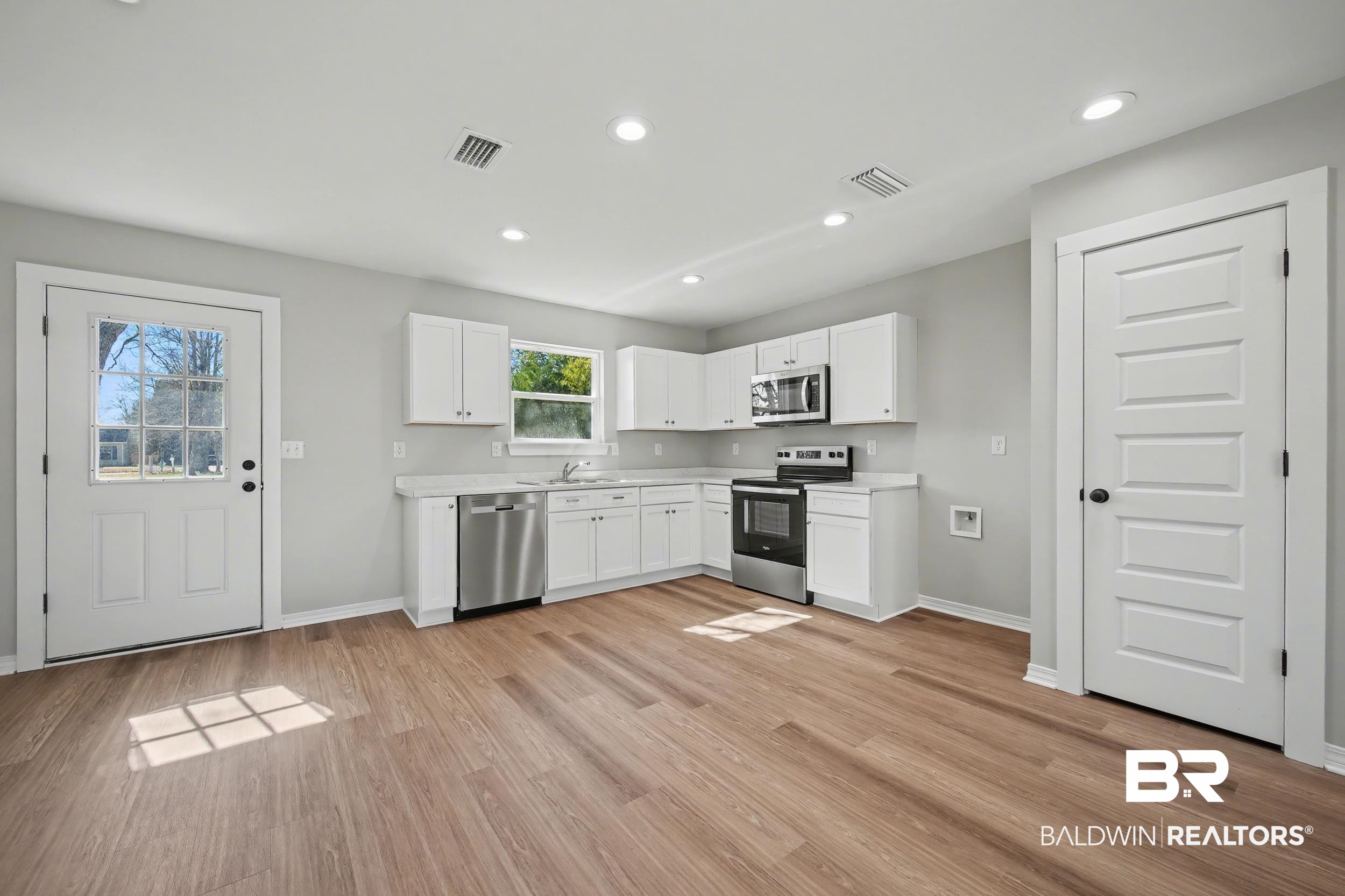 76 Fincher Lane Loxley, AL 36551 - Photo 10 of 33 Kitchen featuring white cabinetry, stainless steel appliances, light countertops, light wood-type flooring, and recessed lighting