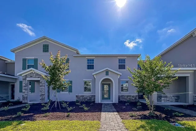 a front view of a house with a yard garage and outdoor seating