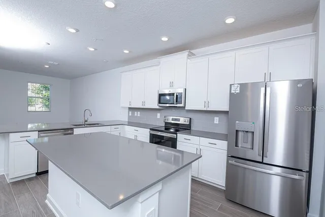 a bathroom with a granite countertop toilet and sink