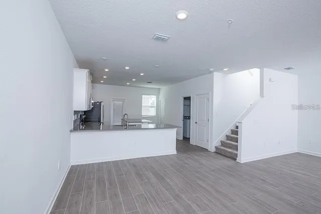 a large kitchen with kitchen island a sink dishwasher a stove and a refrigerator with wooden floor