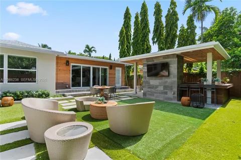 a view of a patio with table and chairs potted plants and palm tree