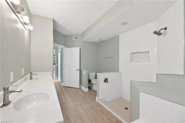 a bathroom with a sink a toilet and shower