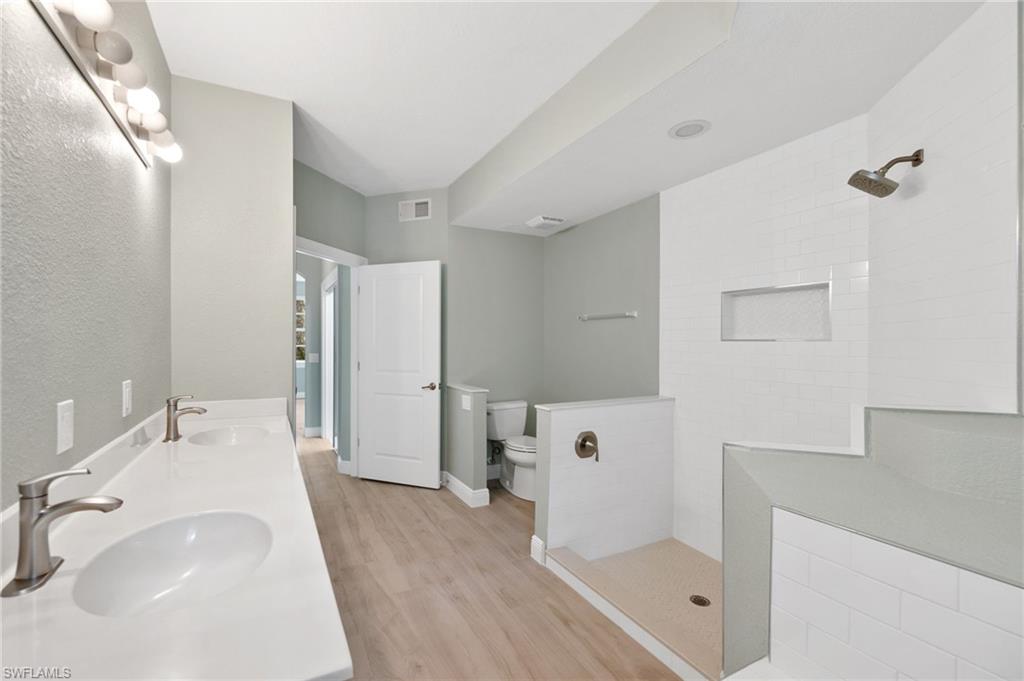 4995 Marsh Turtle Trail, Unit 102 Estero, FL 33928 - Photo 15 of 42 a bathroom with a sink a toilet and shower