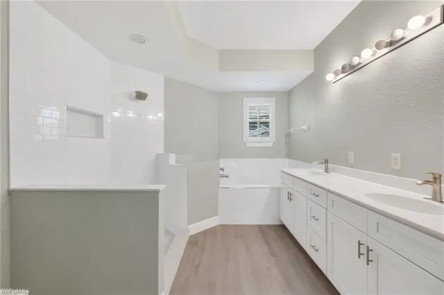 a bathroom with a tub sink and mirror