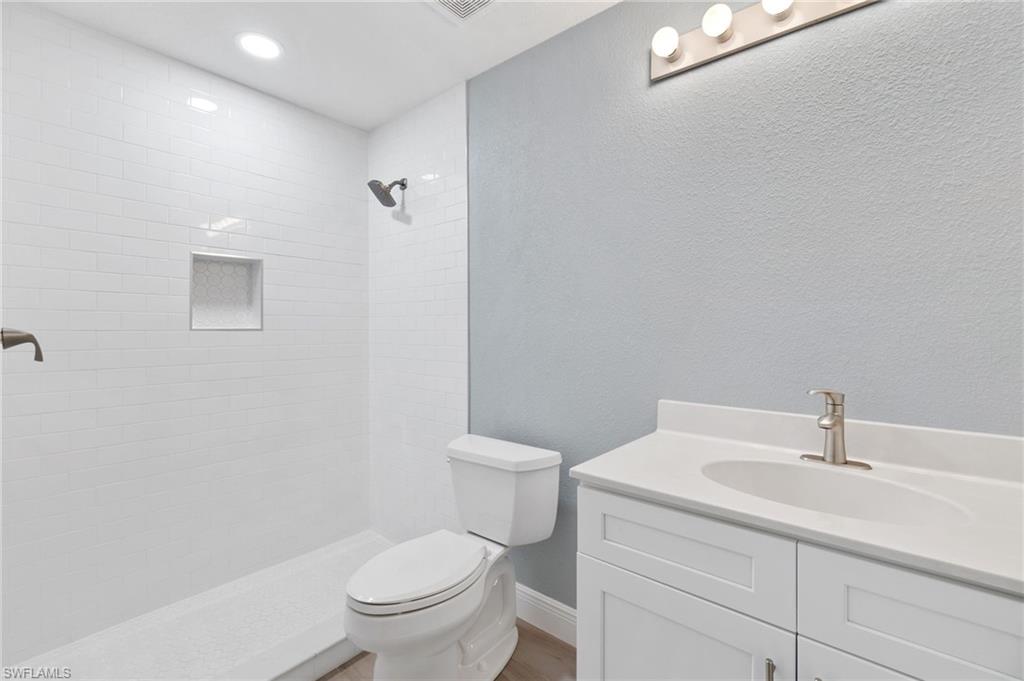 4995 Marsh Turtle Trail, Unit 102 Estero, FL 33928 - Photo 18 of 42 a bathroom with a sink a toilet and a mirror