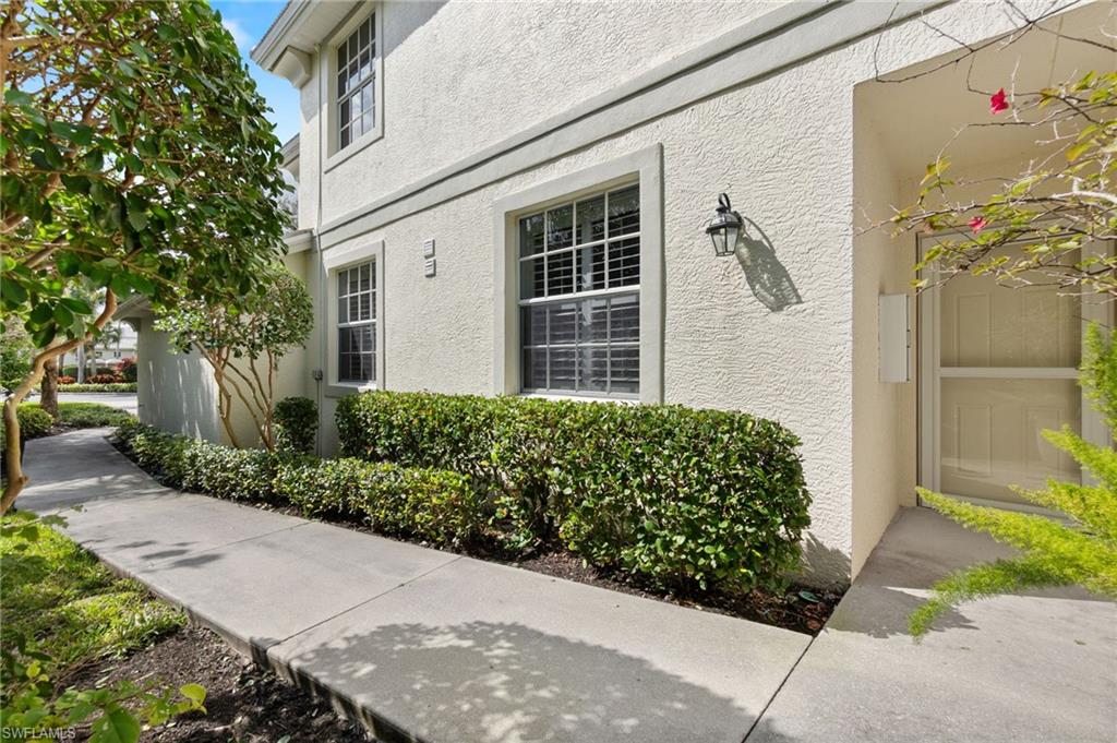 4995 Marsh Turtle Trail, Unit 102 Estero, FL 33928 - Photo 4 of 42 a front view of a house with a garden
