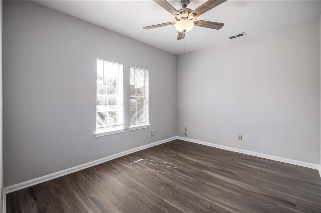 2529 Rio Grande Street, Unit 93 Austin, TX 78705 - Photo 13 of 19 Interior room with light gray walls, two windows, and wood-look flooring