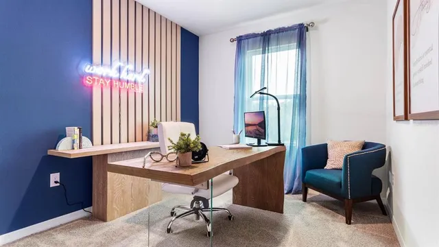 a view of a workspace with furniture and a window