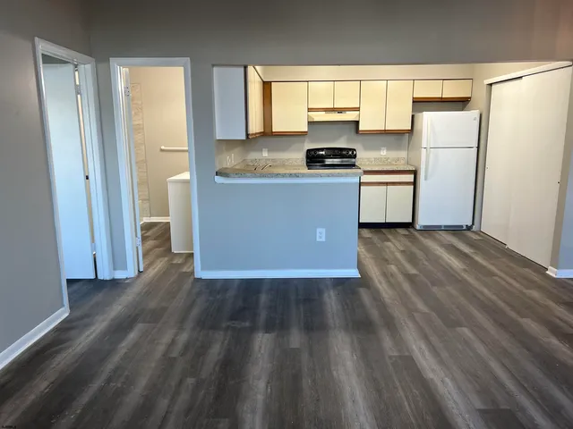 a kitchen with wooden floors and white appliances