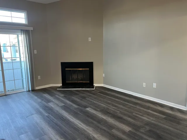 an empty room with wooden floor and fireplace