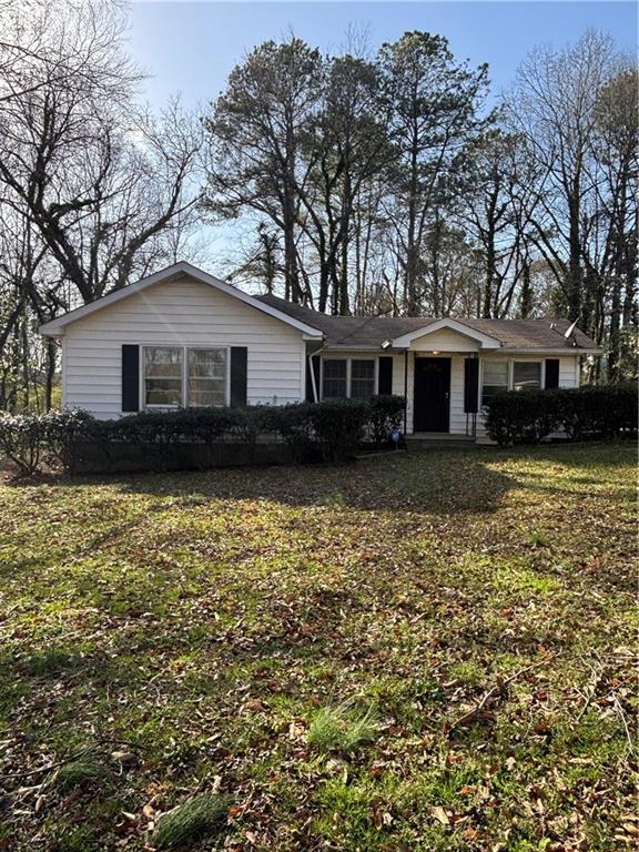 1027 North Born Road Stone Mountain, GA 30088 - Photo 1 of 1 a front view of a house with a garden and trees