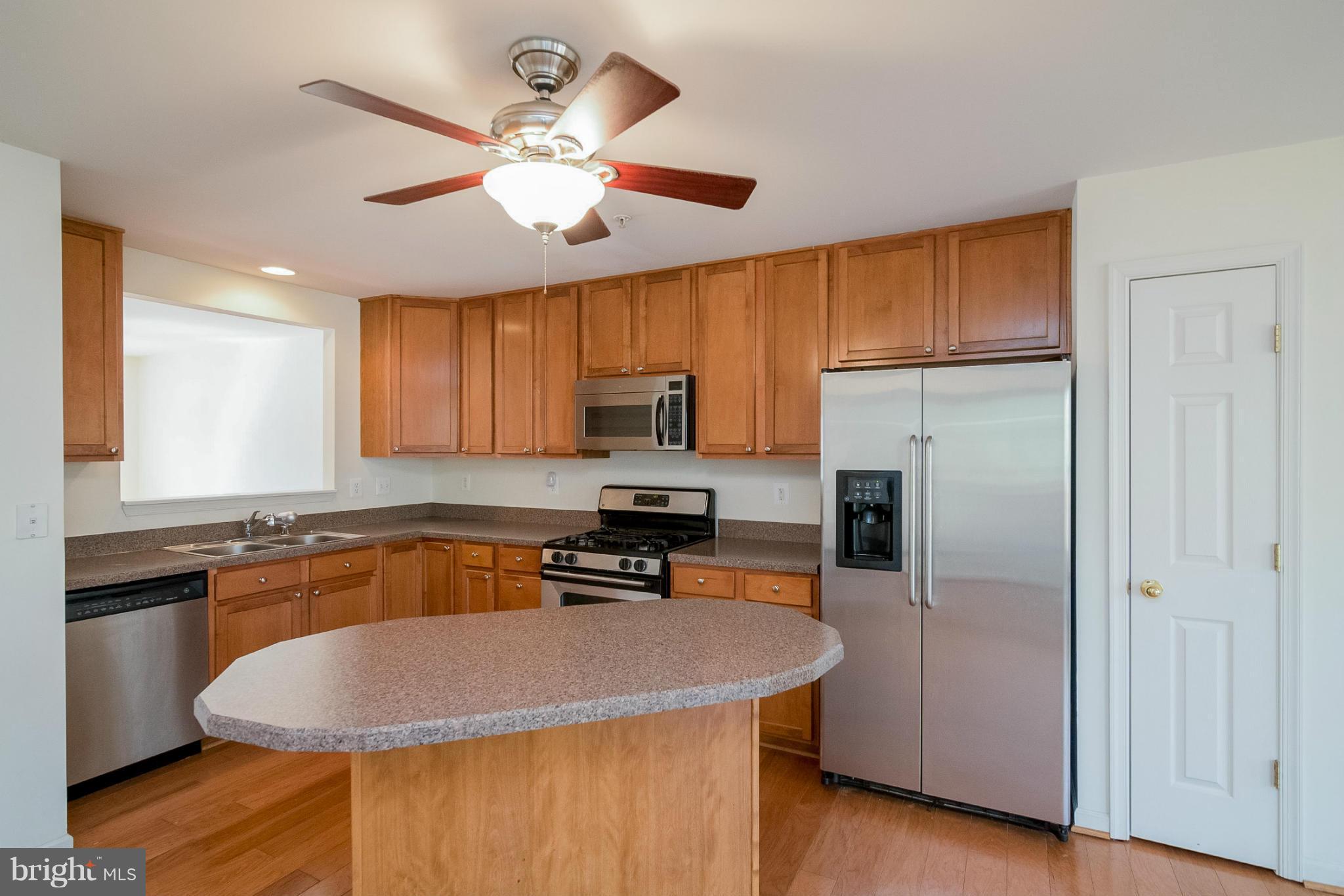 8103 Pennington Drive Laurel, MD 20724 - Photo 2 of 14 a kitchen with stainless steel appliances granite countertop a sink a stove a refrigerator cabinets and wooden floor
