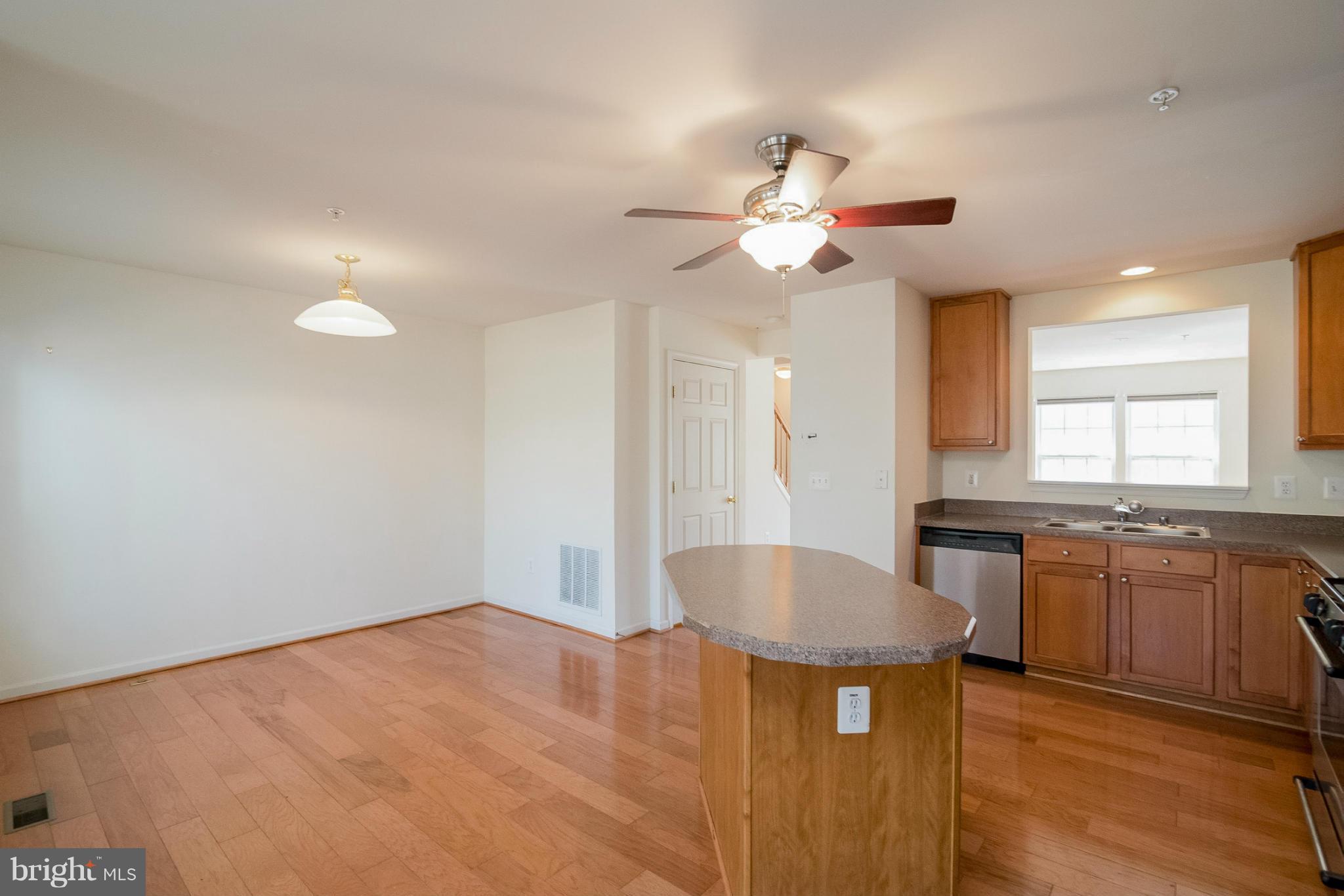 8103 Pennington Drive Laurel, MD 20724 - Photo 4 of 14 a kitchen with stainless steel appliances granite countertop a sink a stove top oven a chimney cabinets and a dining table