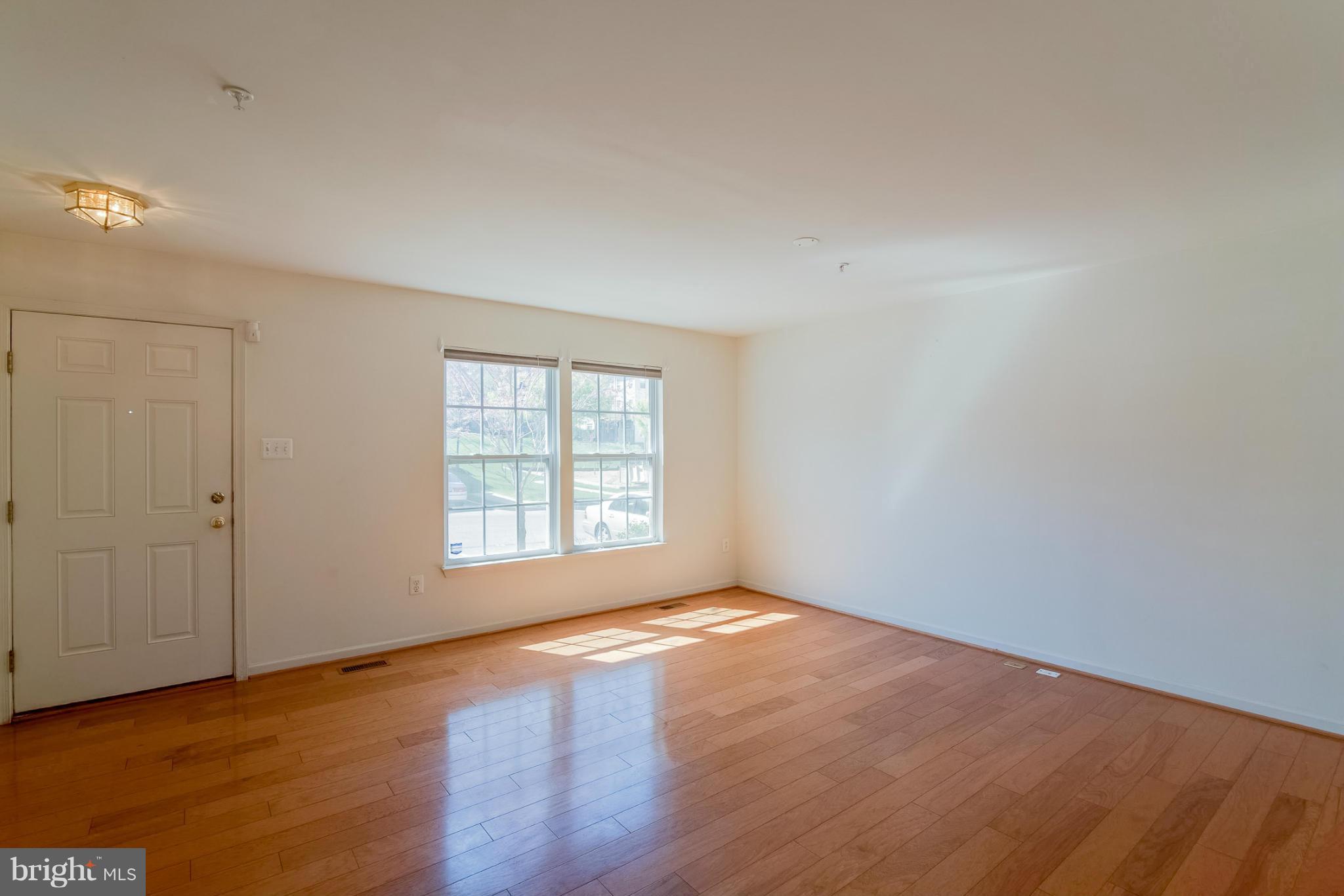 8103 Pennington Drive Laurel, MD 20724 - Photo 6 of 14 a view of an empty room with wooden floor and a window