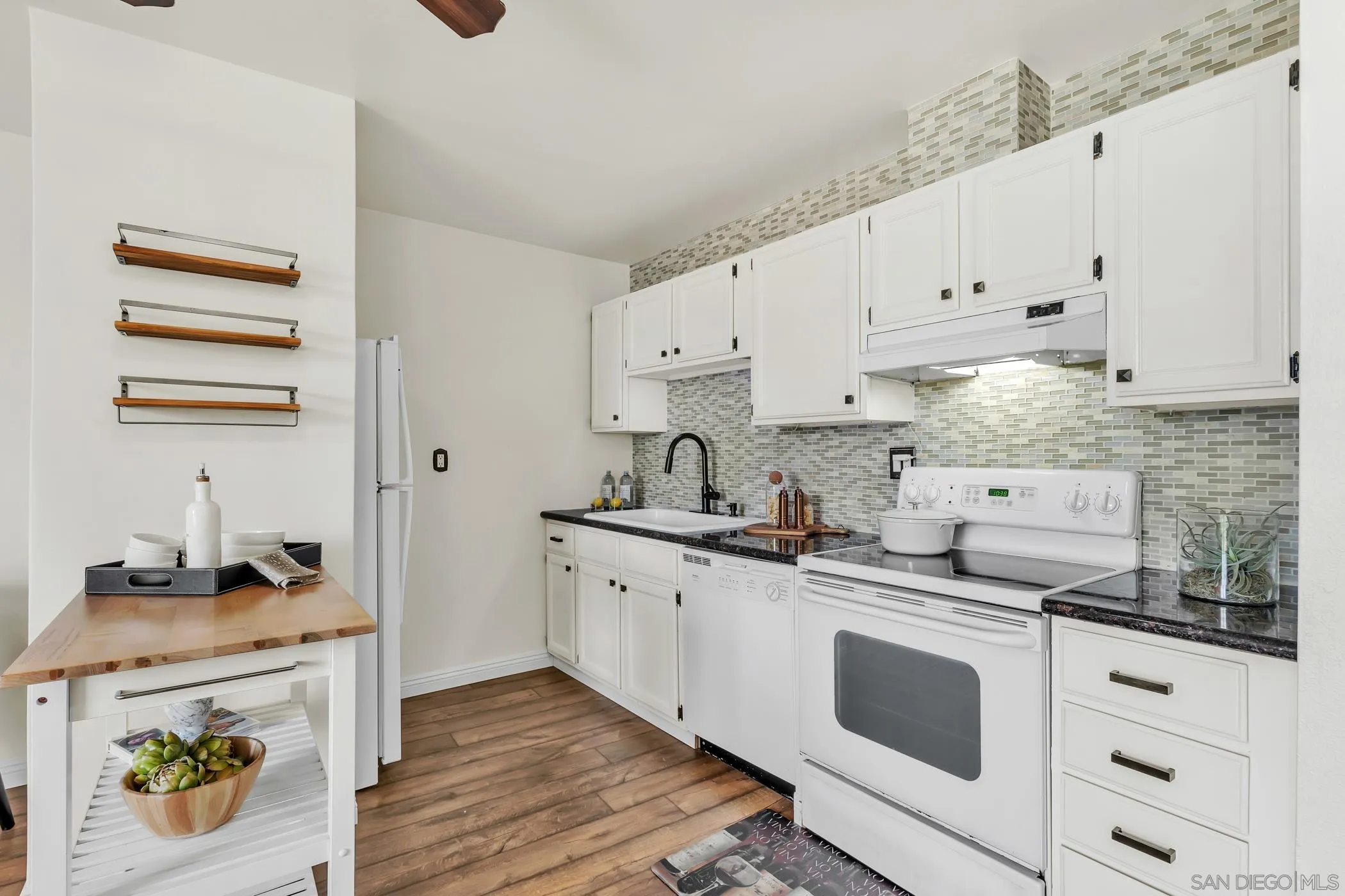 3050 Rue D’Orleans, Unit 461 San Diego, CA 92110 - Photo 6 of 23 a kitchen with granite countertop white cabinets and white appliances