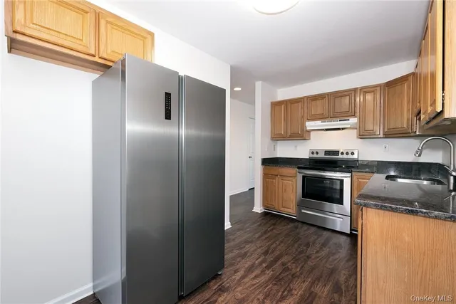a kitchen with stainless steel appliances a refrigerator sink and cabinets