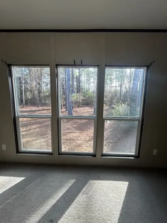 a view of an empty room with a fireplace and a window