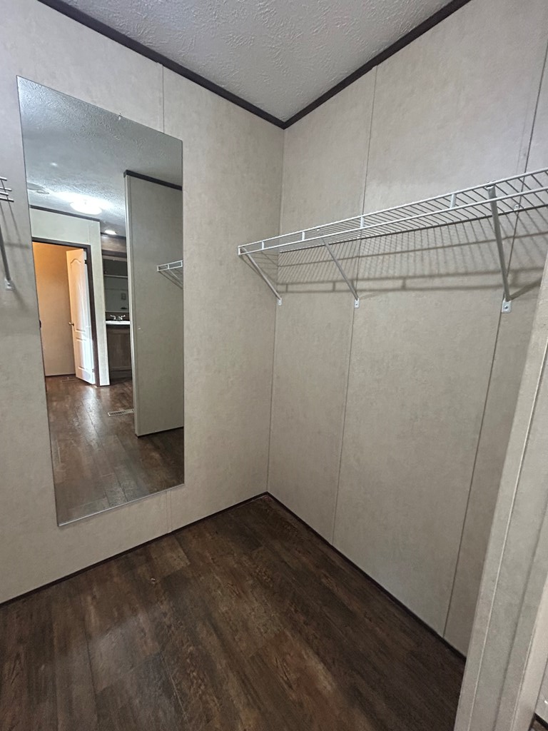 107 Oswichee Road Fort Mitchell, AL 36856 - Photo 7 of 56 an empty room with wooden floor and mirror