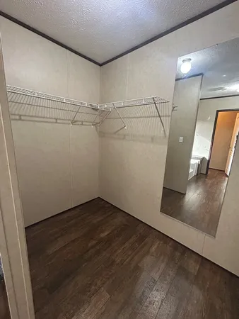 an empty room with wooden floor and white walls