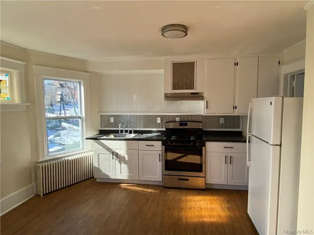 a kitchen with stainless steel appliances granite countertop a stove a sink and a refrigerator