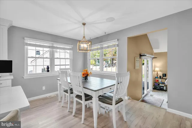 a dining room with furniture a chandelier and wooden floor