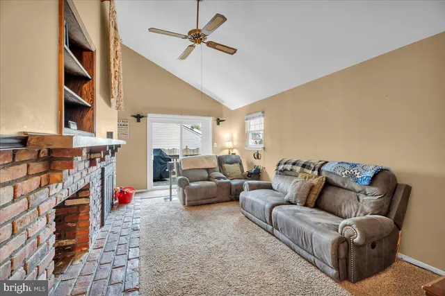 a living room with furniture a ceiling fan and a rug