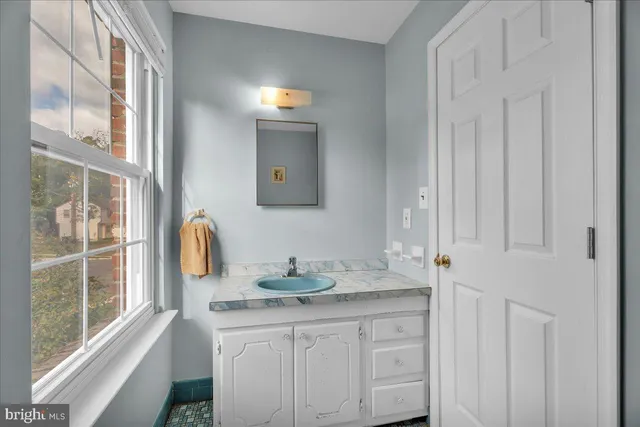 a bathroom with a granite countertop sink and a mirror