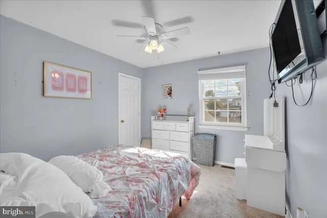 a bedroom with a large bed a flat tv screen and a chandelier