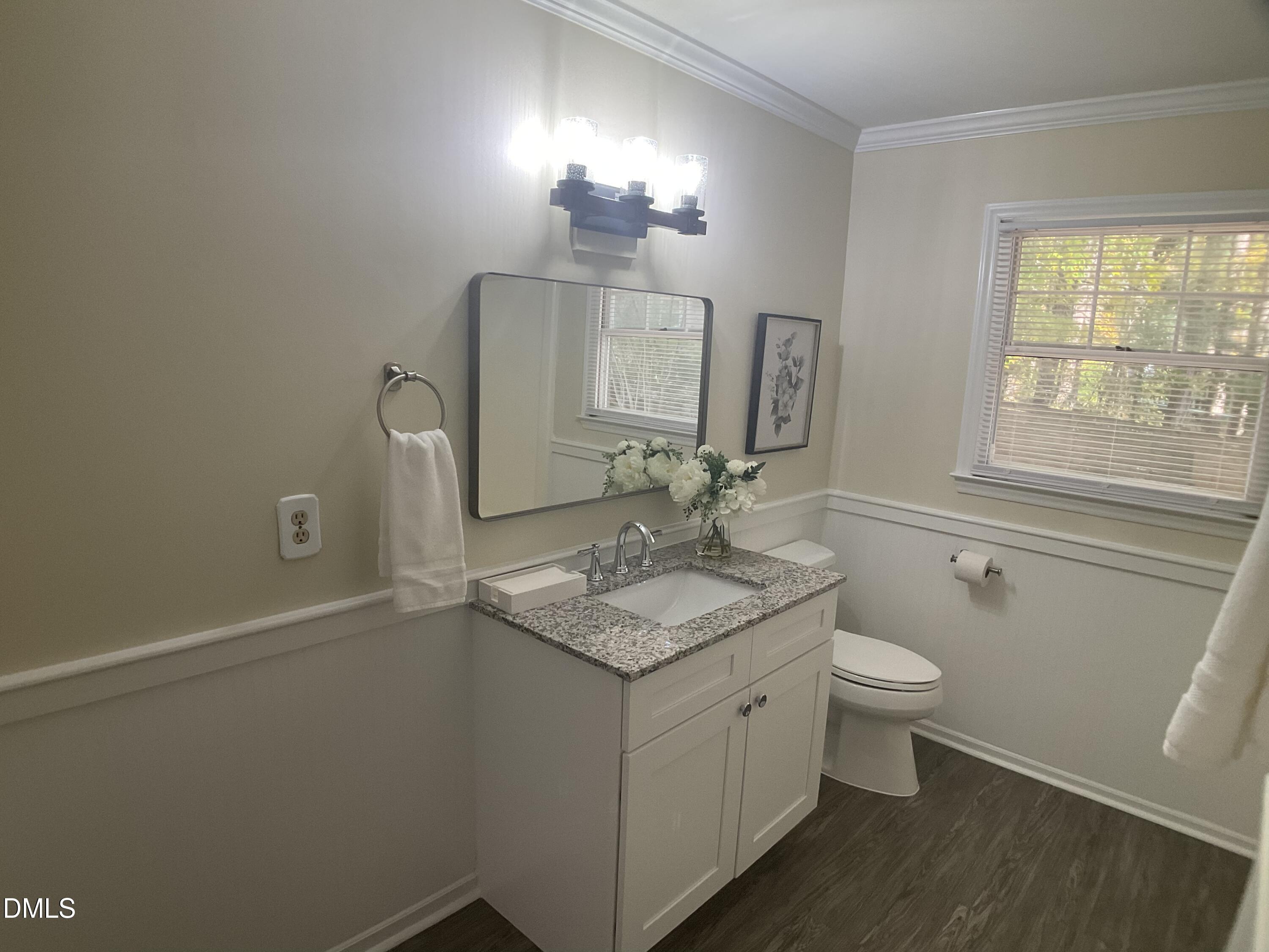 4219 Hope Valley Road Durham, NC 27707 - Photo 22 of 36 a bathroom with a granite countertop sink toilet a large mirror and a window
