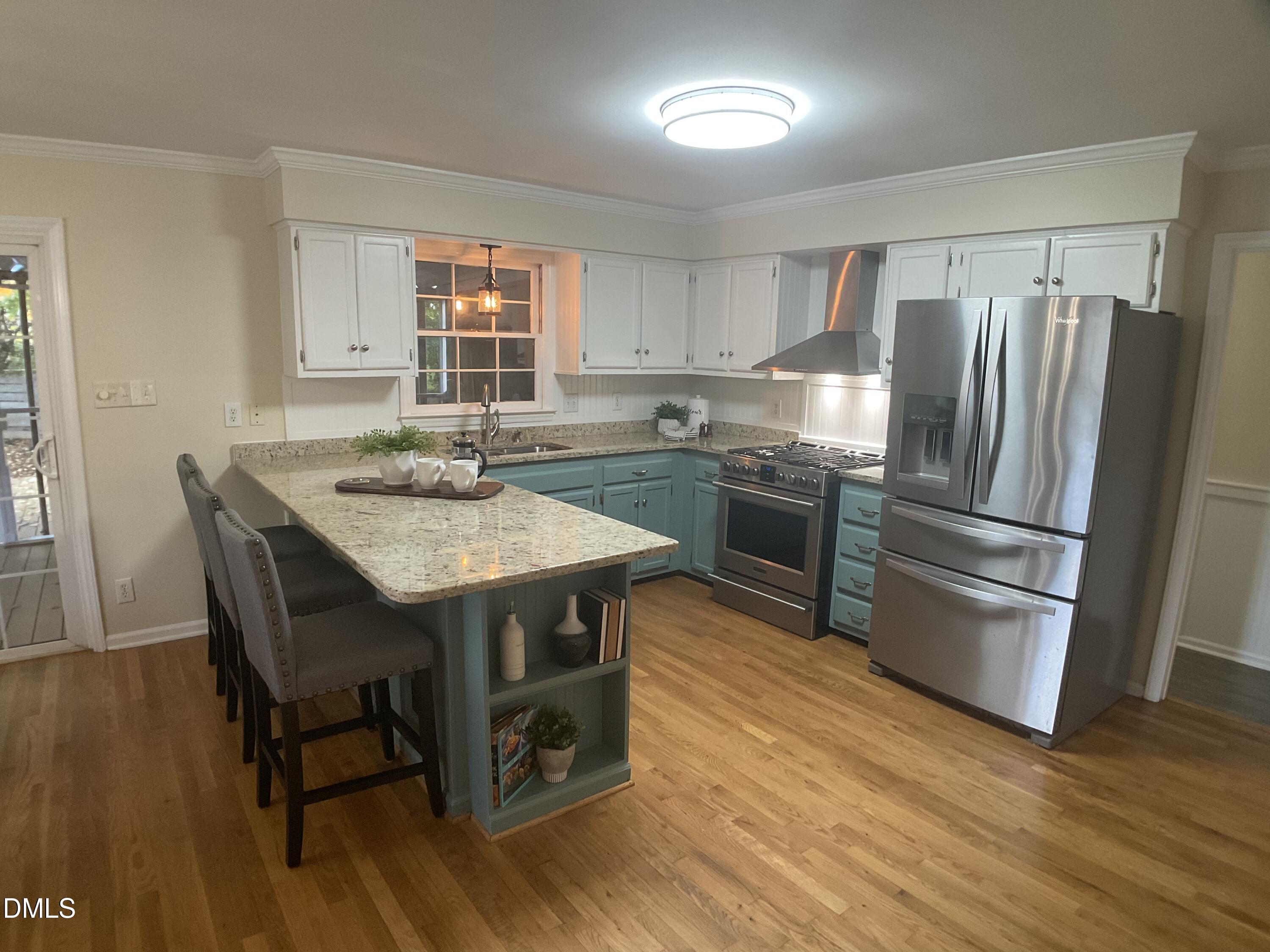 4219 Hope Valley Road Durham, NC 27707 - Photo 3 of 36 a kitchen with stainless steel appliances granite countertop a table chairs stove and refrigerator