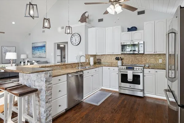 a kitchen with granite countertop white cabinets and white appliances