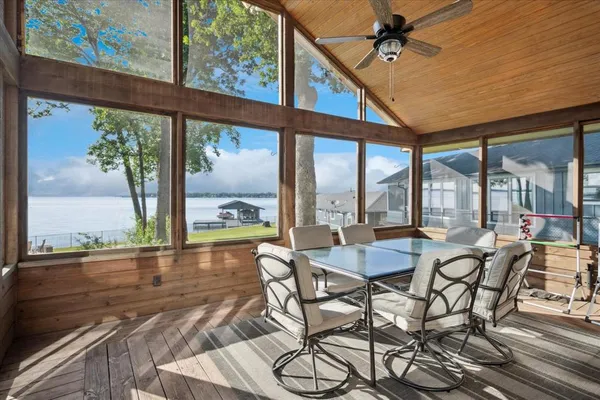 a dining room with furniture water view and a floor to ceiling window