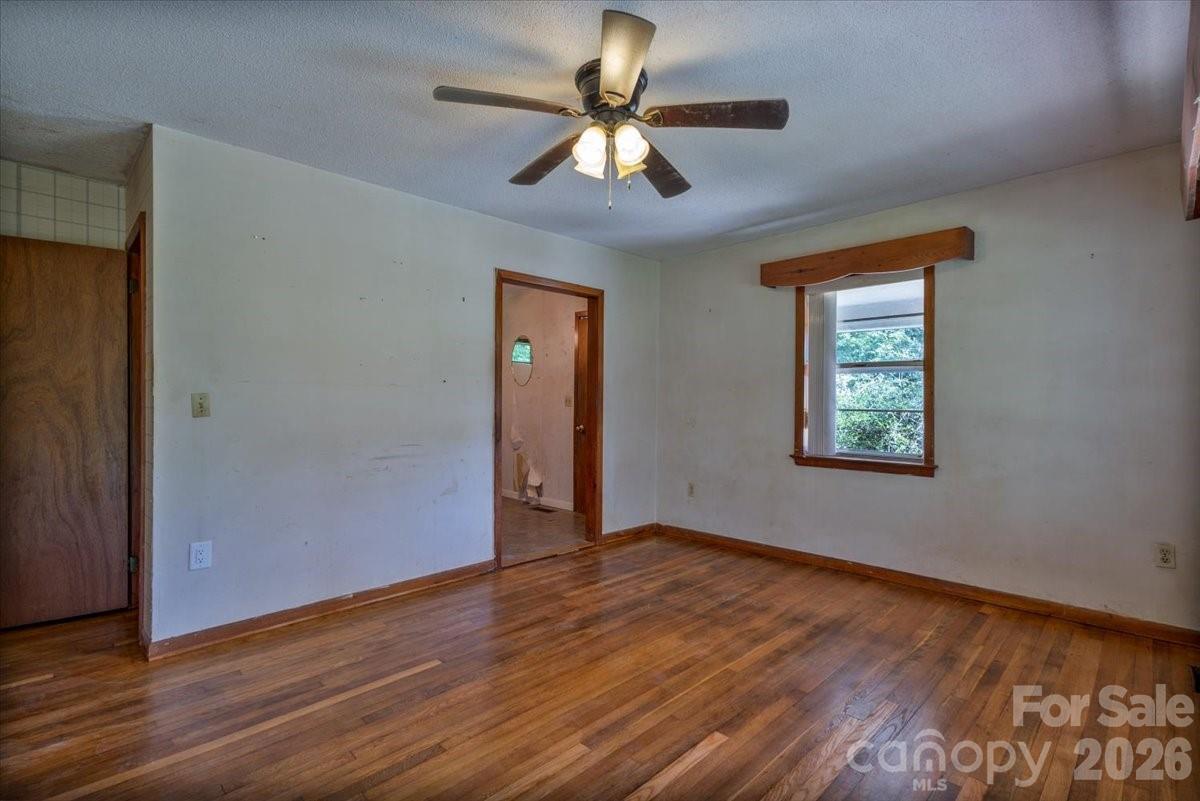 156 Old Sweetwater Road Robbinsville, NC 28771 - Photo 6 of 25 a view of an empty room with window and wooden floor