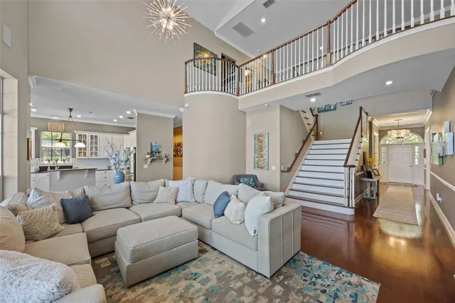 a view of a dining room with furniture a chandelier and wooden floor